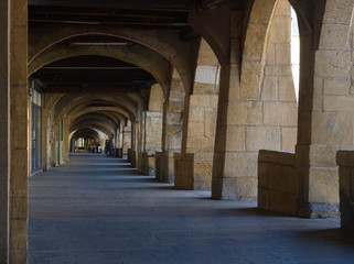 Fototapeta na wymiar Perspective view under the arcades of Place Saint Louis in Metz
