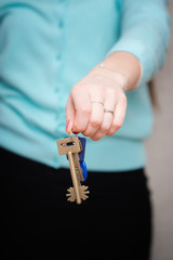 woman with keys. isolated on gray background
