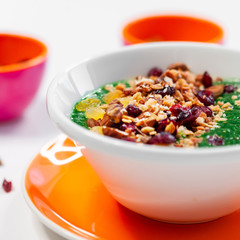 fresh greens and granola smoothie on white table. Healthy vegan food.