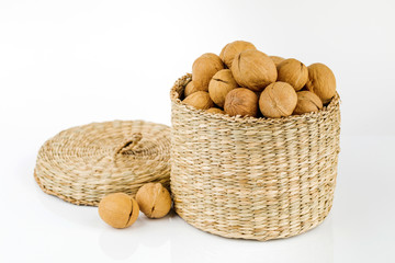 wicker box with walnuts isolated on white background