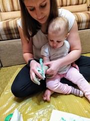 Mother wipes daughters hand with napkin from paint