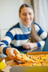 Young business woman concentrating on work and eating pizza