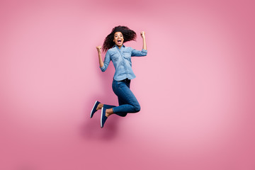Fototapeta na wymiar Full body photo of delighted afro american girl hear lottery win news impressed scream yeah jump raise fists feel euphoria emotions wear casual style outfit isolated pink color background