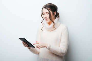 Happy young woman using tablet computer isolated on gray background