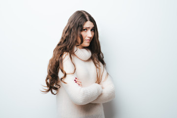 Obraz premium Young businesswoman is standing and folding her arms on her chest. The friendly woman is looking at the camera and smiling.
