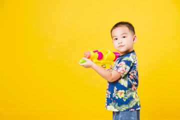 little children boy so happy in Songkran festival day holding water gun