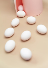 Creative Easter beige and pink background with white eggs.