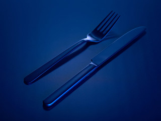 Blue knife and fork on a blue beautiful background. You can change the color.