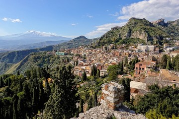 Obraz premium Cityscape of the Taormina city in Sicily, Italy and mountains with Etna volcano in background