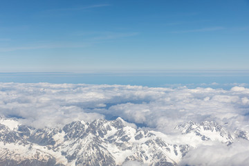 Fototapeta na wymiar Aerial view of snow capped mountains and blue skies in New Zealand