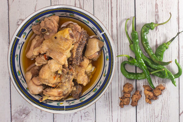 Spicy chicken meat dishes with chili on white wooden background