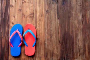 Colorful slipper pair on wooden background during sunny day