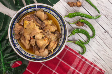 Spicy chicken meat dishes with chili on white wooden background