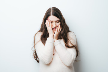 portrait of beautiful long-haired girl tired on a white background