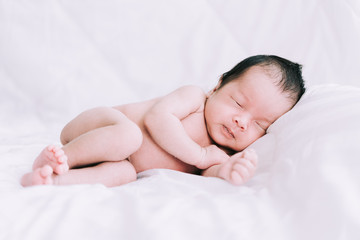 Smiling baby boy lying on a white bed, Family morning at home,Children hygiene.