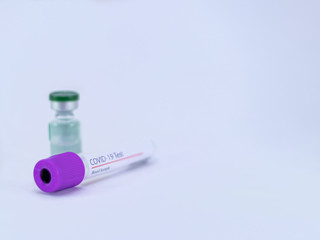 Close up shot of an  empty COVID 19 test sample collection tube with a medicine vial on white background.