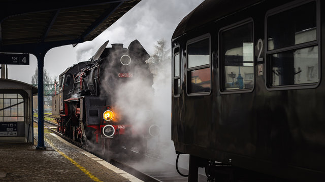 Lokomotywa parowa podczas manewr&oacute;w na peronie  stacji kolejowej