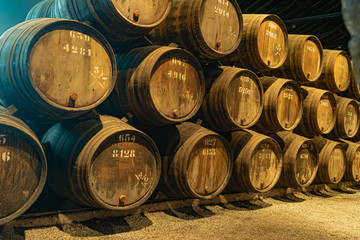 Row of wooden porto wine barrels in wine cellar Porto, Portugal.