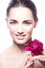 Naklejka premium Beautiful young fashion model woman beauty posing portrait with pnk flower near face. Perfect skin, natural make-up, happy smile. Isolated. White background