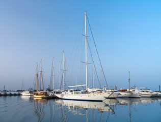 Fototapeta premium yacht in marine with reflections in water in the morning in Greece