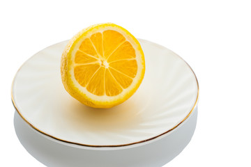 fresh yellow lemon on a plate on a white background close up