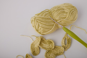 A bright set of knitted flowers. Homemade flowers crochet, multi-colored cotton yarn, crochet hooks on a white background with a copy of the space for text. Easy handmade crochet concept