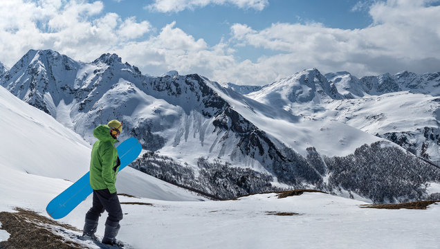 Freerider with splitboard or snowboard for ski touring at winter mountains background