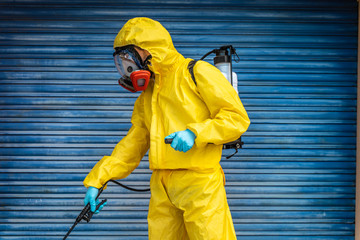 Coronavirus. A sanitation worker wearing a mask and cleaning the streets radiation virus with...