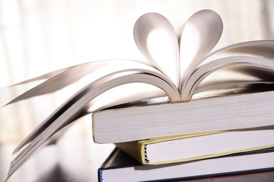 High key image of book with open page folded a heart shape