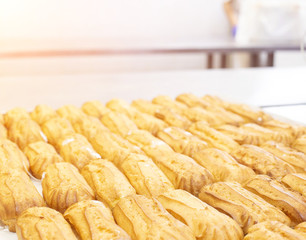 Confectionery for the production of desserts and sweets, making custard cake eclairs with cream and coconut, delicatessen