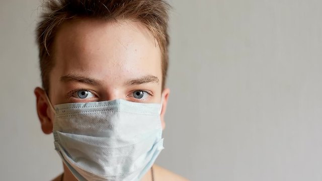 self-isolation and quarantine, portrait of a teenage boy in a medical mask, protection from viruses and diseases