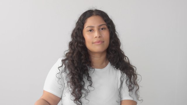 Mixed race plus size woman without makeup in studio wit long wavy dark hair