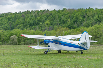 Old retro plane takes off from the small mountain airport.