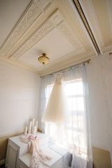 Bridesmaid wedding dress hanging on the window