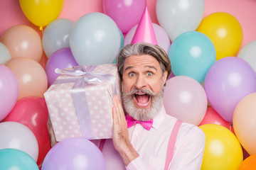 Close-up portrait of his he nice attractive cheerful cheery funky grey-haired mature man having fun holding in hands giftbox isolated over pink pastel color background