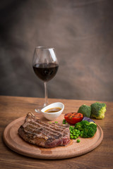 Steak with grilled vegetables and seasoning on serving plate
