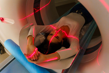 Red rays scan a girl on computed tomography CT scan of the abdomen for a woman to cure...