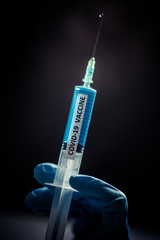 Hand holding a syringe with the coronavirus COVID-19 vaccine