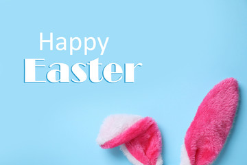 Decorative Easter bunny ears on light blue background, flat lay