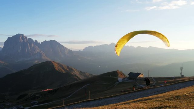Paraglider run and accelerates himself to take off from the mountain of Seceda.