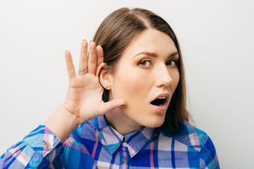 Closeup of emotional shocked woman surprised girl with hand to ear listening secret gossip or quiet...