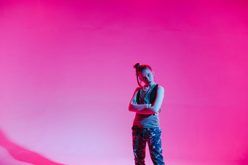 Young stylish girl dancing in the Studio on a colored neon background. Music dj poster design.