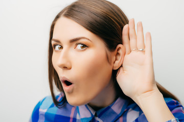 Closeup of emotional shocked woman surprised girl with hand to ear listening secret gossip or quiet...