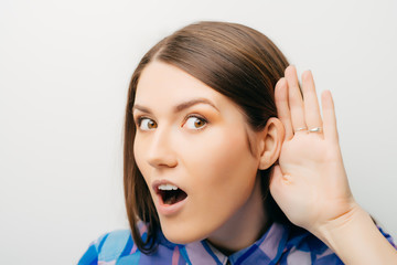 Closeup of emotional shocked woman surprised girl with hand to ear listening secret gossip or quiet...