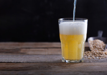 Homemade craft beer in a glass, dark wooden background