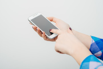 young woman typing on mobile phone on white background
