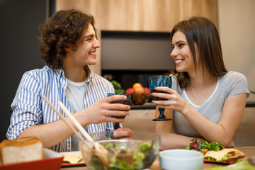 Romantic evening, couplespend time at home kitchen with wine glasses