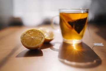 Black tea with lemon on wooden table. Tea bag with lemon slice in cup