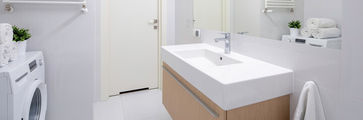 Simple bathroom with long washbasin, panorama