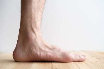 Closeup of male flatfoot legs isolated on white background - obrazy, fototapety, plakaty